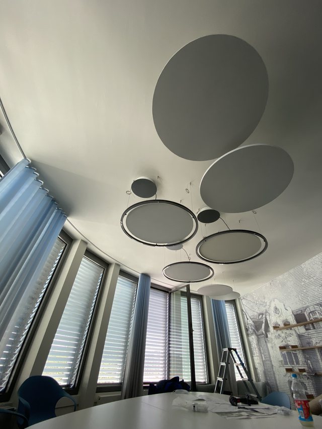 Bürodecke mit runden Akustiksegeln und LED-Ringleuchten