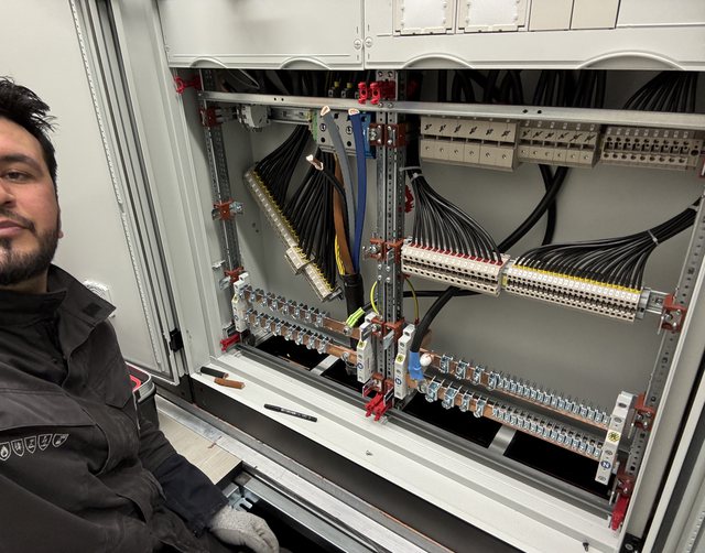 Elektriker von Zaheen Elektrotechnik vor einem im Aufbau befindlichen Schaltschrank