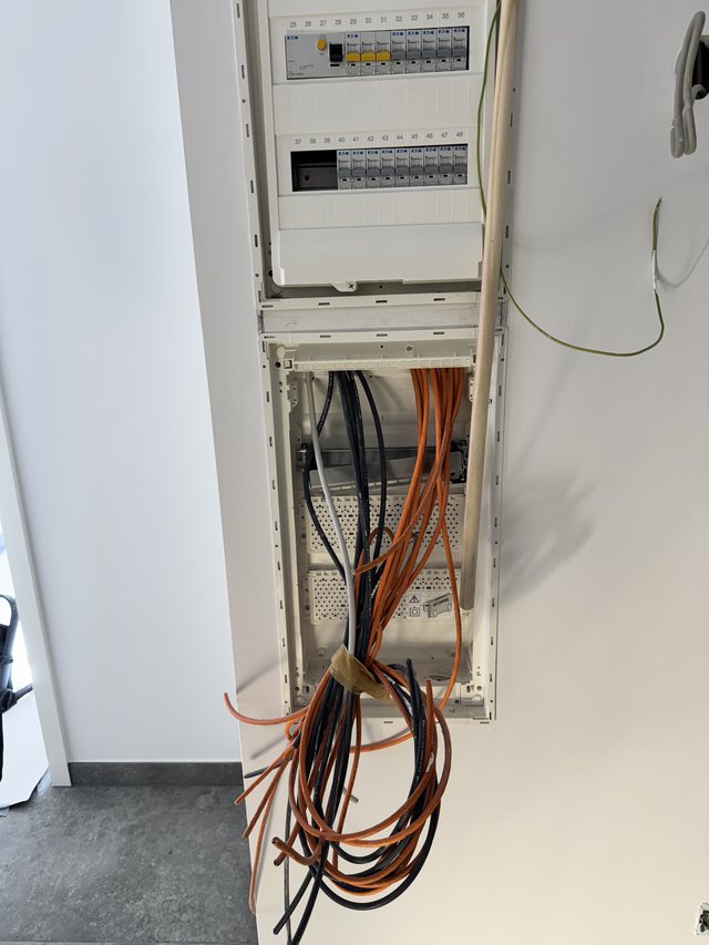 Verteilerschrank im Rohbau mit eingezogenen Zuleitungen vor dem Anschluss